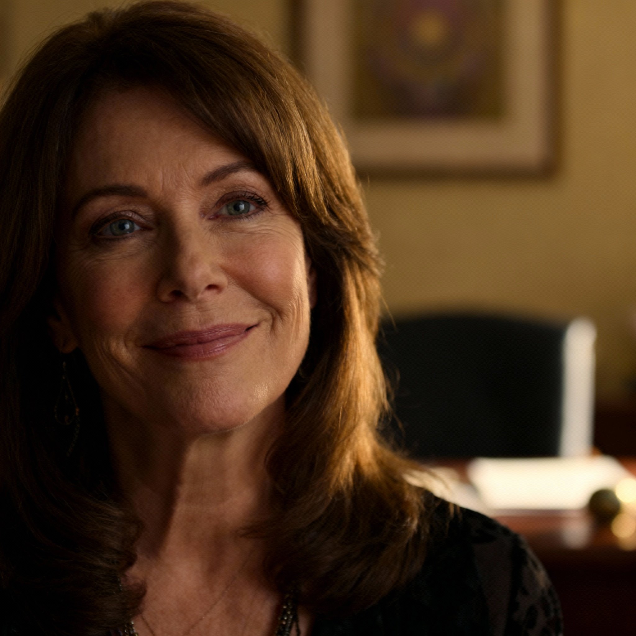 A close-up portrait of a mature psychic advisor, Joan Marie Lawson, whose wise and compassionate eyes and warm smile convey a sense of trustworthiness.